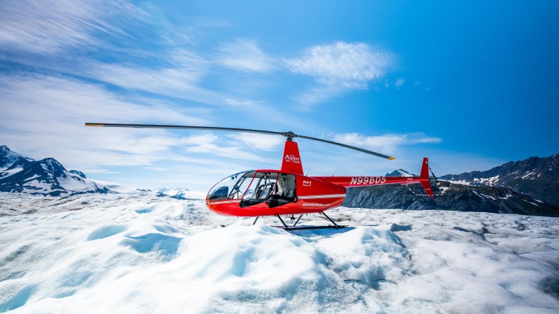 Helicóptero vermelho pousado sobre uma geleira no Alasca, numa excursão para viajantes de cruzeiros