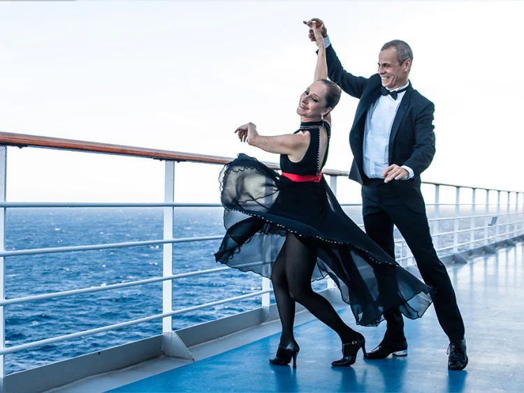Dançando a Bordo: Ana Botafogo e Carlinhos de Jesus dançando em um deck externo do navio
