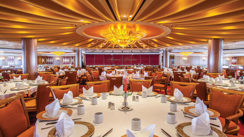 Restaurante do navio Costa Victoria, da Costa Cruzeiros, com mesas postas e teto iluminado
