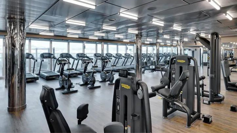 Sala da academia Technogym no navio MSC Seaside, com fileiras contendo várias esteiras e aparelhos de musculação.