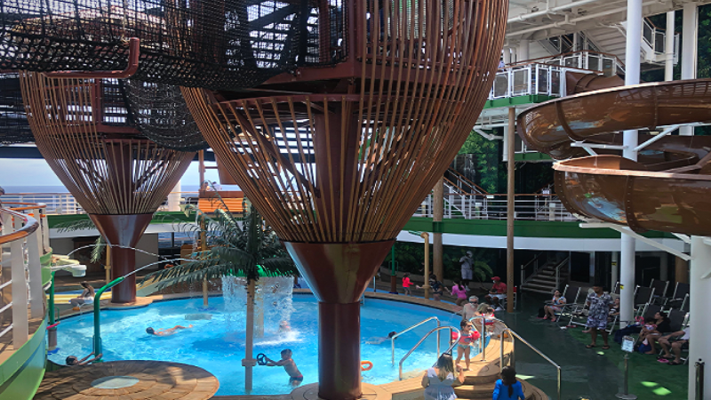 Parque aquático infantil do navio MSC Seaside, com piscina infantil, tobogãs de água e torres com escadaria para acesso as pontes de corda.