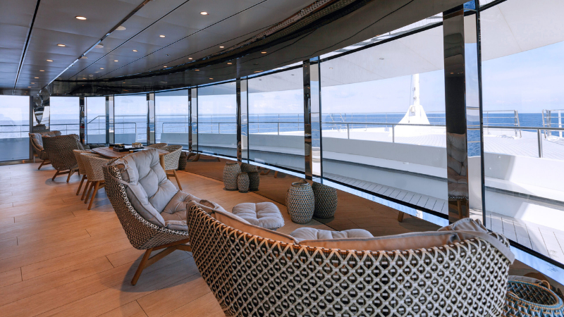Lounge com vista panorâmica decorado por grandes poltronas do iate Emerald Azzurra