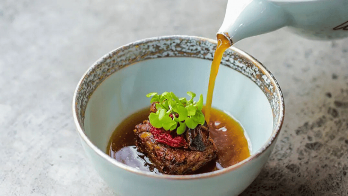 Sop buntut com caldo de rabo de boi e dashi, cebola carbonizada e tomate com passas